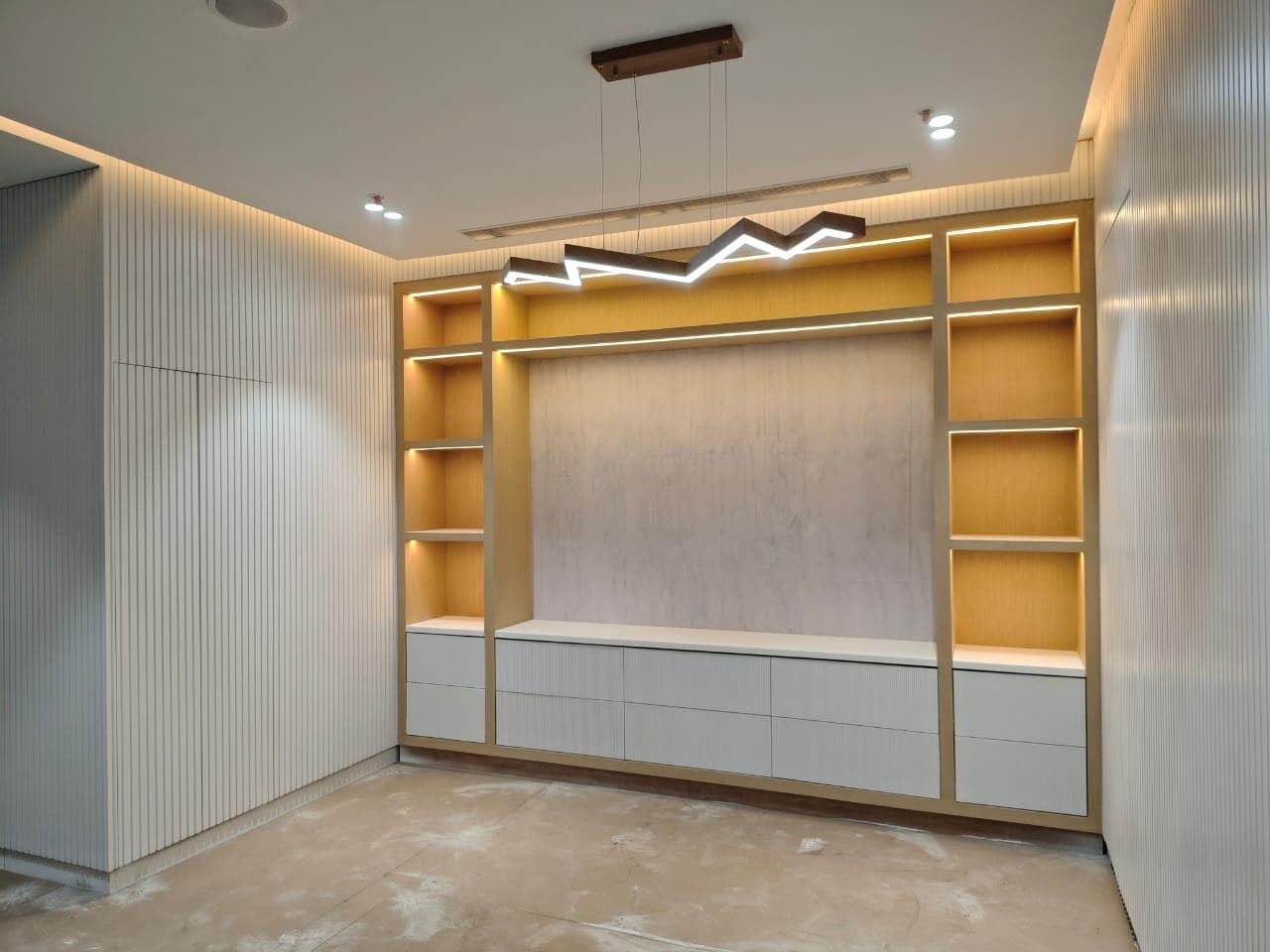 A completed Studio Arc Interiors living room feature wall with backlit shelving